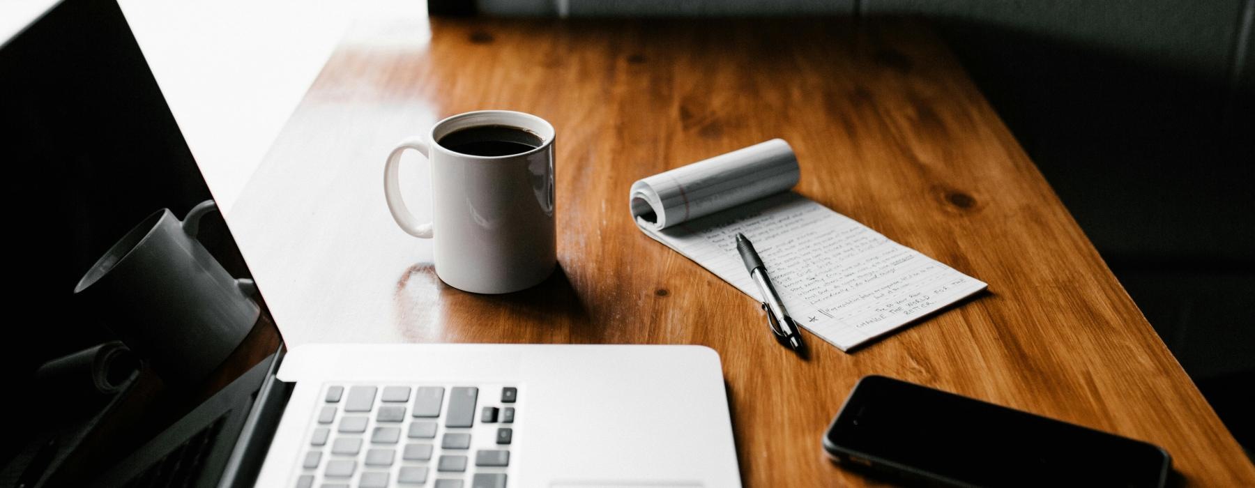 a laptop and a cup of coffee on a desk
